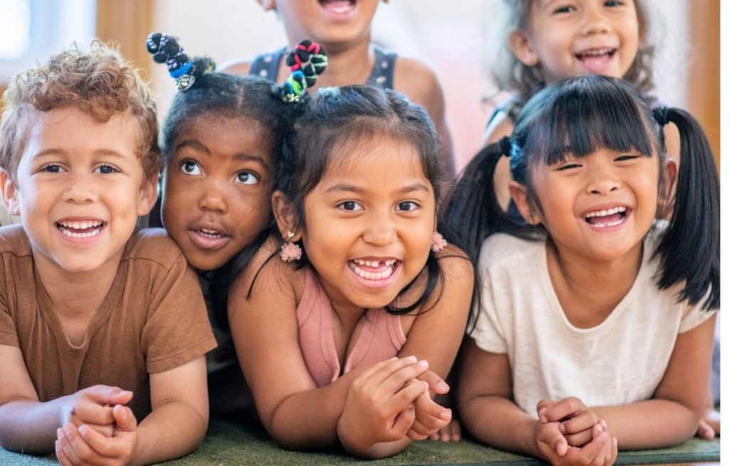 A diverse group of six young children smiling.