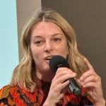 Amy Klein Molk speaking into a microphone.